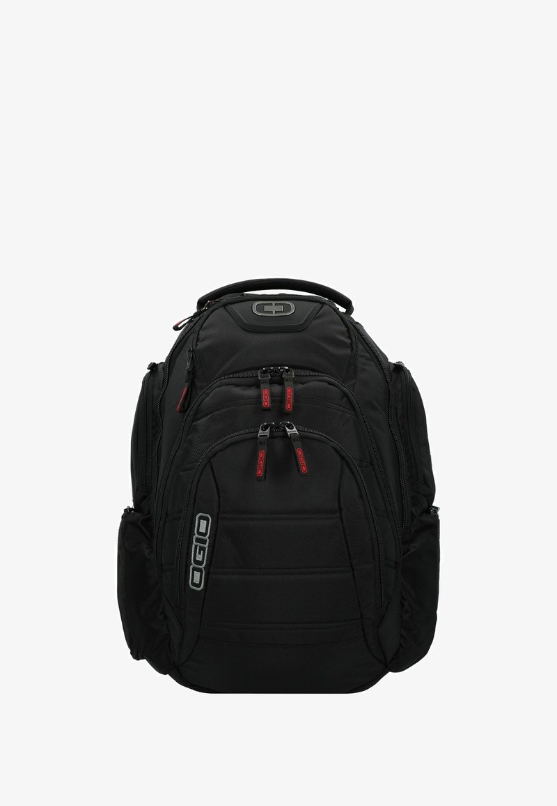 Mochila negra con múltiples compartimentos con cremallera, panel trasero acolchado y correas ajustables. Presenta acentos rojos y un logotipo en el frente.