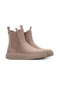 Botas de tobillo beige de ante con paneles laterales elásticos, pequeñas lengüetas de tiro y suelas de goma texturizada con estrías horizontales.