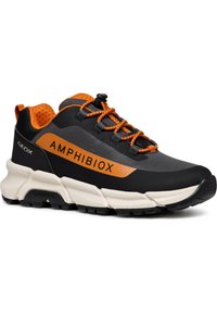 Zapatilla negra y naranja con una parte superior texturizada y forro de malla. Presenta cordones en contraste, gruesa suela blanca y la marca 'AMHIBIOX'.