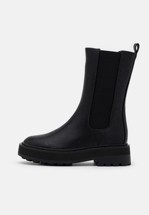 Black mid-calf leather boot with chunky sole, elastic side panel, and pull tab on a plain white background.
