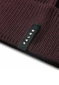 Berretto lavorato a maglia bordeaux con texture a coste e un'etichetta nera con la scritta bianca "FALKE" sul lato.