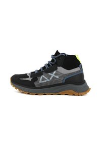 Scarpa da trekking alta nera e grigia con accenti testurizzati, lacci blu, dettagli riflettenti e suola in gomma con un motivo di battistrada frastagliato.