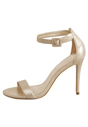 Gouden metalen sandaal met hoge hak, enkelbandje, open teen en een smalle stilettohak. Soepele textuur met minimalistisch design.