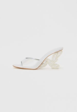 Sandalo aperto bianco con tomaia in satin, dettaglio argento e un tacco intagliato a forma di farfalla. Suola piatta con una texture liscia.