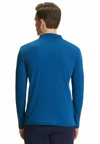 Langarm-Polohemd in Royalblau, mit klassischem Kragen, glattem Stoff und geradem Saum mit seitlichen Schlitzen.