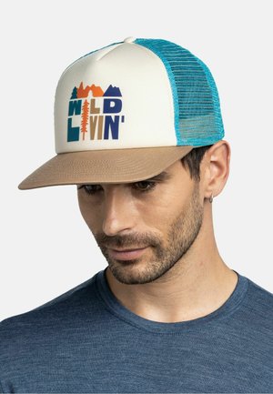 Mann trägt eine weiße und blaue Mesh-Trucker-Kappe mit braunem Schirm, mit einem „WILD LIVIN'“-Logo mit Bäumen und Bergen, und ein blaues Hemd.