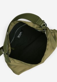 Oliwkowa torba z miękkim zewnętrzem z materiałów recyklingowych, gładkim skórzanym paskiem oraz zamkiem błyskawicznym, który odsłania czarne wnętrze.