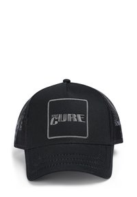 Melnā kravas cepure ar acs aizmuguri, ar izšūtu uzlīmi "THE CURE" pelēkā krāsā. Strukturēta priekšējā daļa ar noapaļotu rēķinu un izšūšanas detaļām.