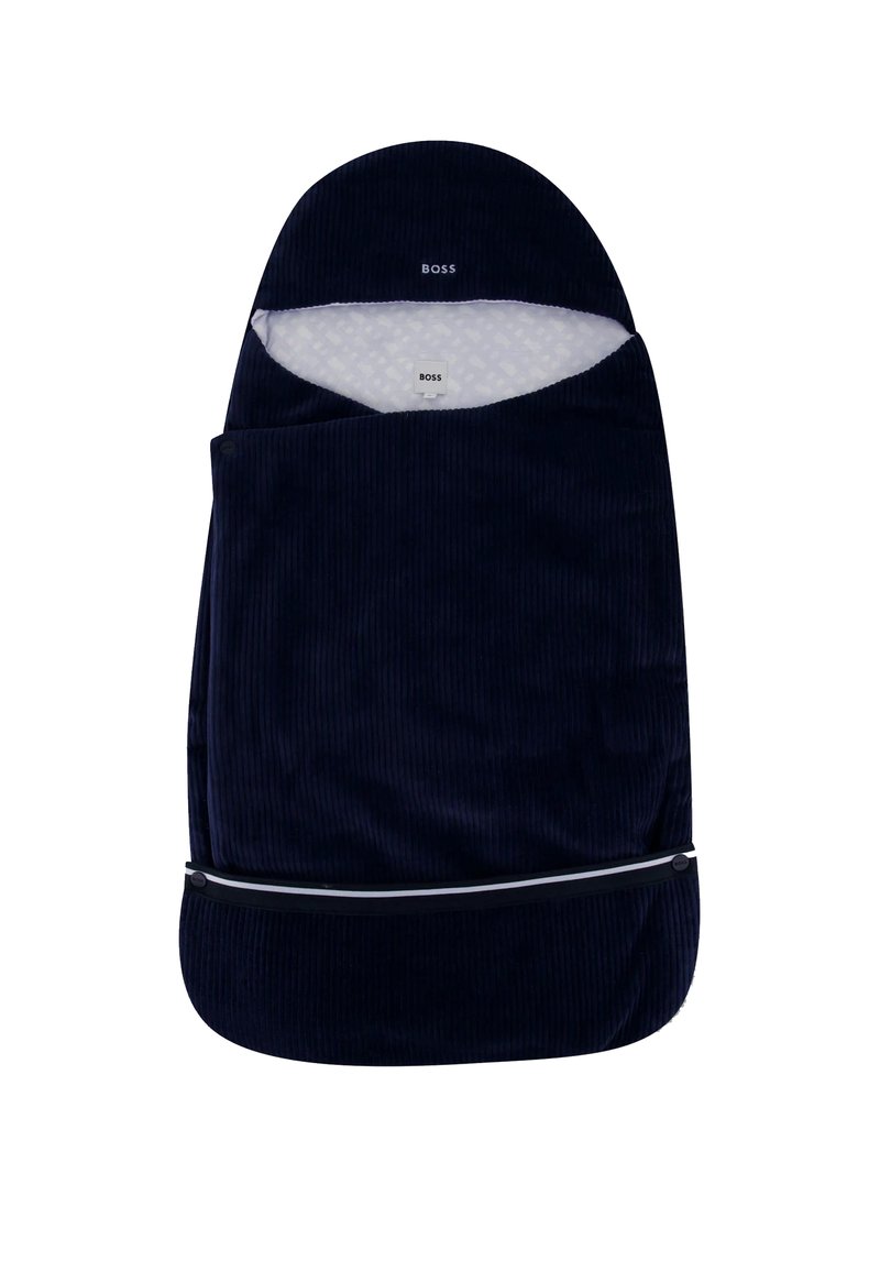 Saco de couchage bébé en velours côtelé bleu foncé avec une doublure blanche à motifs et une fermeture éclair noire en bas. Logo de la marque visible en haut.