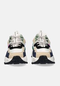 Zapatillas con un diseño de múltiples materiales; los colores incluyen beige, verde y azul marino. Presentan cordones texturizados, un detalle reflectante y una suela gruesa.