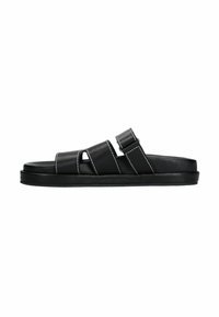 Zwarte leren sandalen met twee horizontale banden, een enkele teenopening en een platte zool; heeft contrasterende witte stiksels.
