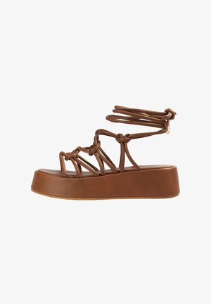 Hnědé platformové sandály s propletenými pásky, vrstveným designem, hladkým povrchem a zaoblenou špičkou. Součástí jsou nastavitelné vazby kolem kotníků.