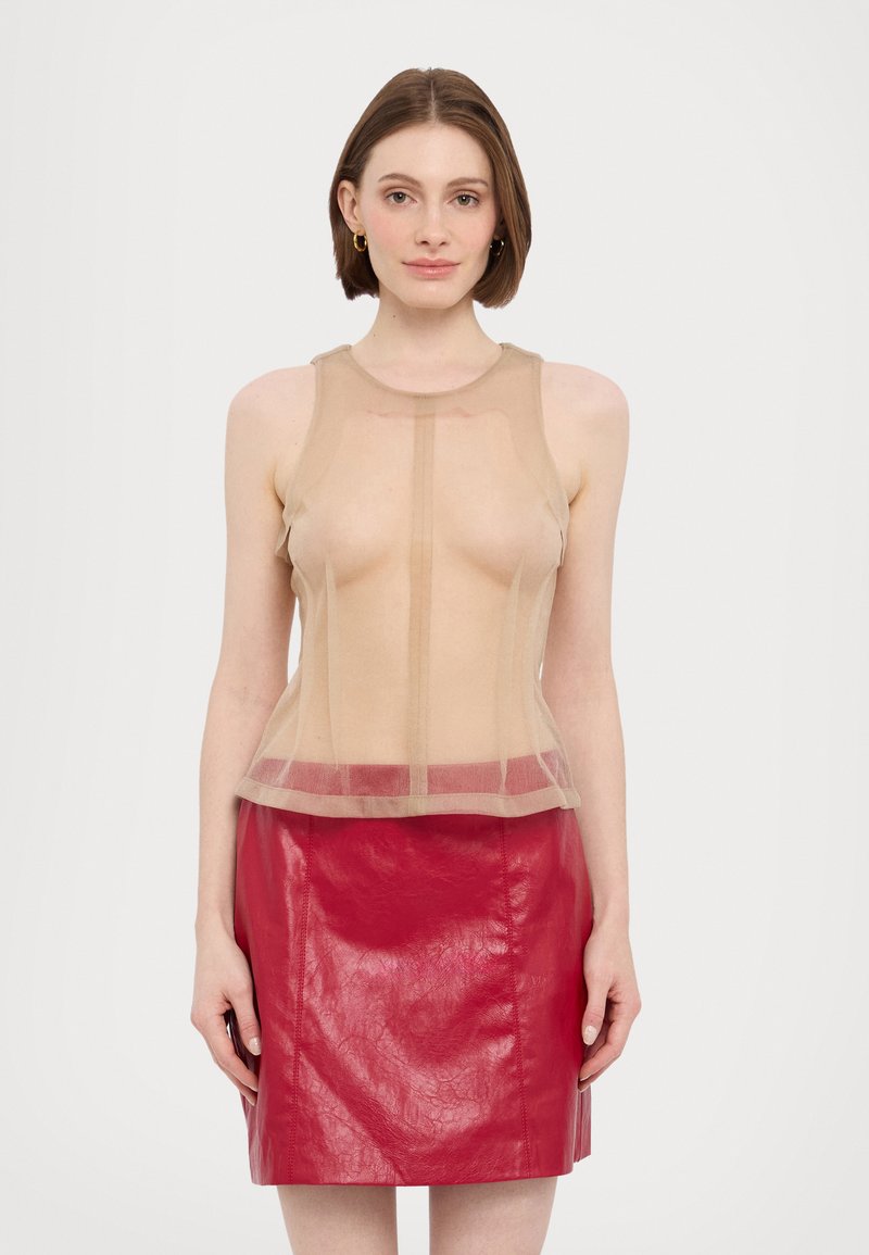 Beige gennemsigtig top med ærmeløs design, har en lige skæring og bredere kant. Kombineret med en tætsiddende rød læder mini-nederdel med en skinnende overflade.