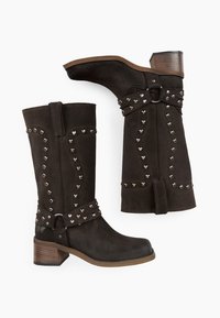 Stivali ankle in suede marrone con borchie argentate, una fascia decorativa con fibbia e tacco impilato. Finitura testurizzata con dettagli di design curvi.