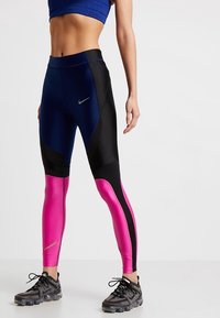 Högpresterande leggings med blå, svarta och rosa paneler. Har en slät textur, stretchigt tyg och Nike-logotyp på midjebandet.