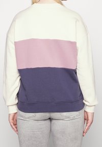 Felpa color block con sezioni crema, rosa e blu navy; texture morbida; collo a giro standard; vestibilità rilassata; polsini e orlo a coste.