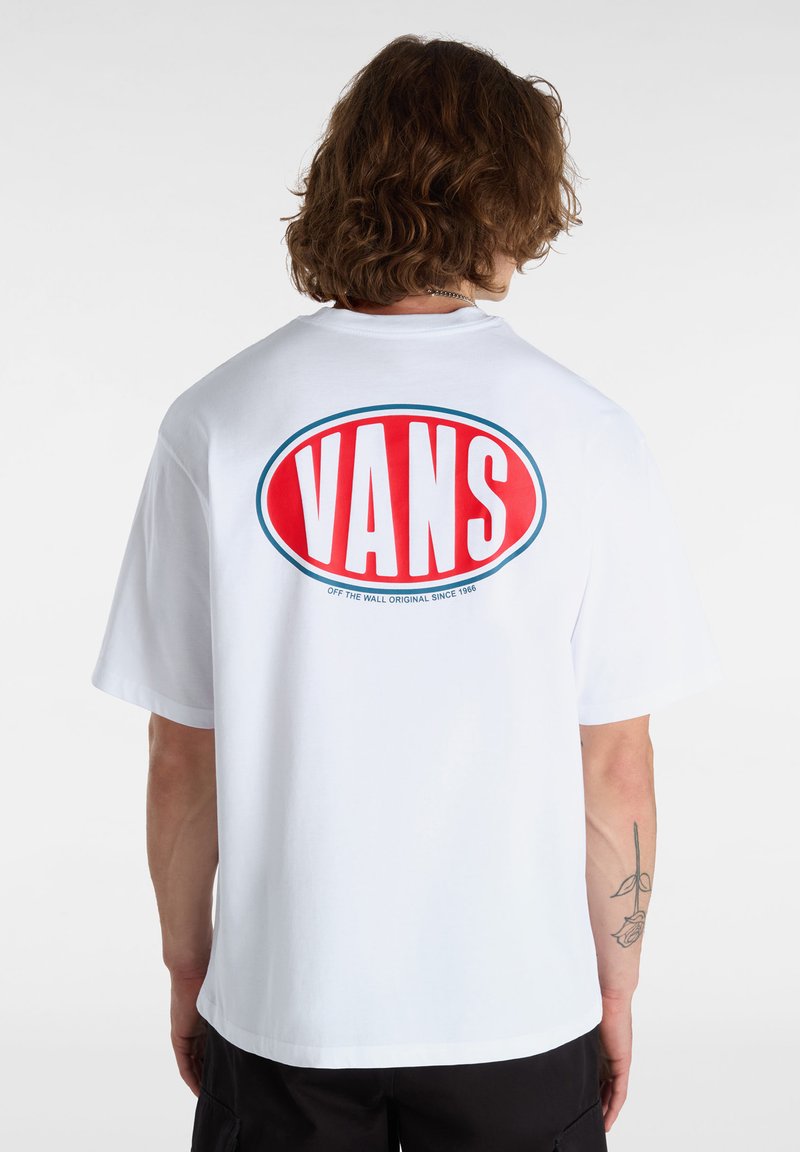 Bílý bavlněný tričko s velkým červeným a modrým oválným logem, na kterém je výrazně zobrazeno text "VANS" na zádech. Krátké rukávy a volný střih.