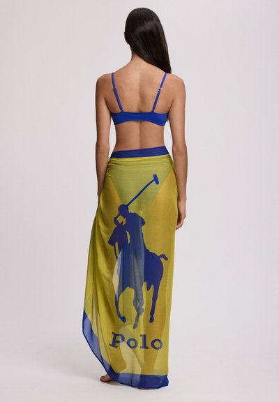 Paréo de marque Polo en jaune et bleu, avec un grand motif de cheval et cavalier. Fabriqué en tissu léger et transparent, avec un design fluide.