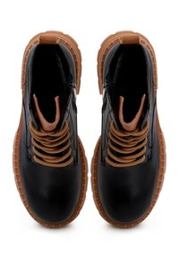 Bottines en cuir noir avec lacets couleur tan, fermeture éclair, et semelles en caoutchouc texturées. Caractérisées par une finition lisse et un col matelassé.