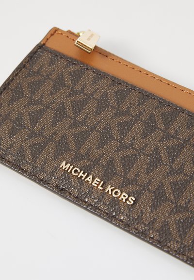 Portefeuille en cuir marron texturé présentant un design de logo et de motifs. Accentué par du cuir beige en haut et des éléments en métal doré.