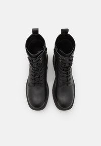 Pair of black leather lace-up ankle boots with side zippers and pull tabs, shown from above on a white background.