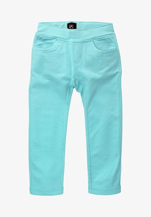 Leggings turquoise en tissu doux, avec une large ceinture et deux poches avant avec des coutures le long des coutures.