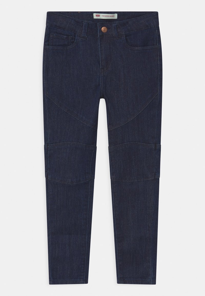 Jean slim en denim bleu foncé avec bouton frontal, passants de ceinture et coutures distinctes aux genoux et aux cuisses supérieures.