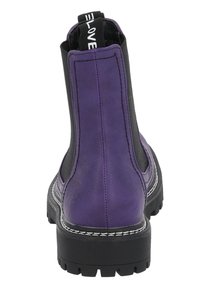 Botas de tobillo de cuero morado con paneles elásticos laterales negros, suelas de goma negras y detalles de costura blanca. Etiqueta de lazo en la parte trasera.