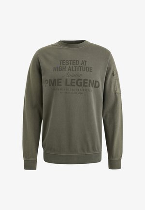 Maslinasto zeleni dukserica izrađena od mekog materijala. Sadrži grafiku sa tekstom na prednjoj strani i bočnu džepu. Okrugli izrez i rebrasti rukavi.