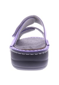 Purple sandals with multiple straps on a platform sole. Soft textured insole, contrasting white stitching, and a dark grey base.