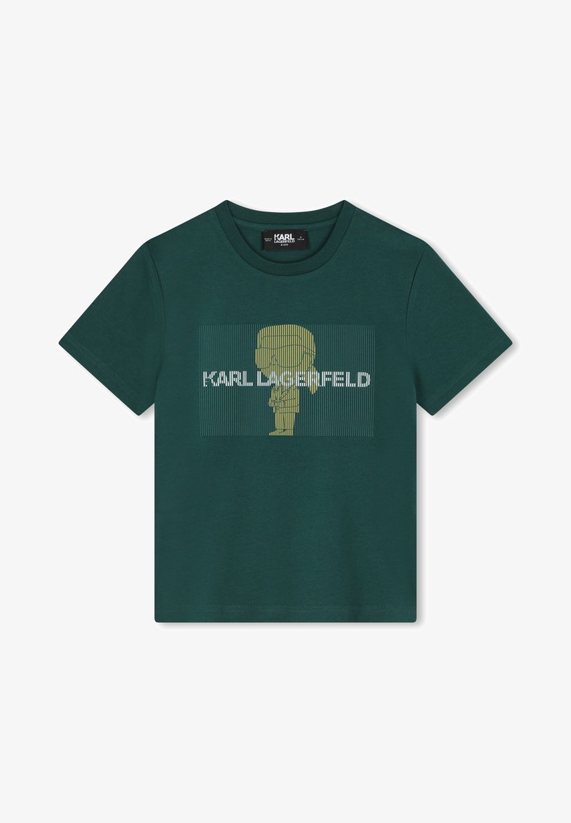 T-shirt en coton vert présentant un graphisme doré d'une silhouette de personnage et le texte "KARL LAGERFELD" en blanc, avec des lignes verticales en fond.