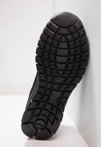 Svart atletisk skosula med texturerad gummi, med ett mönstrat mönster för grepp och hållbarhet; synlig häl med rundad kant.