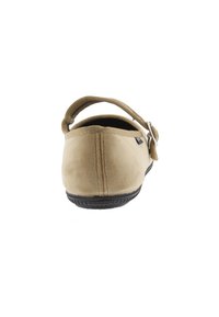 Zapato de tela beige sin cordones con una correa trasera, puntera redonda, parte superior texturizada y suela de goma negra. Presenta un detalle de hebilla plateada.