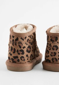 Leopardmönstrade anklarstövlar i brun mocka med en mjuk, vit faux fur-foder. Rund tå och sula i syntetgummi. Stängd bakkonstruktion.