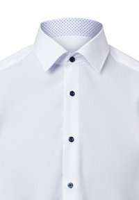 Weißes Hemd mit marineblauen Knöpfen, ausgestattet mit einem gemusterten blauen Innenkragen. Glatte Textur, klassischer Schnitt, geeignet für formelle Anlässe.