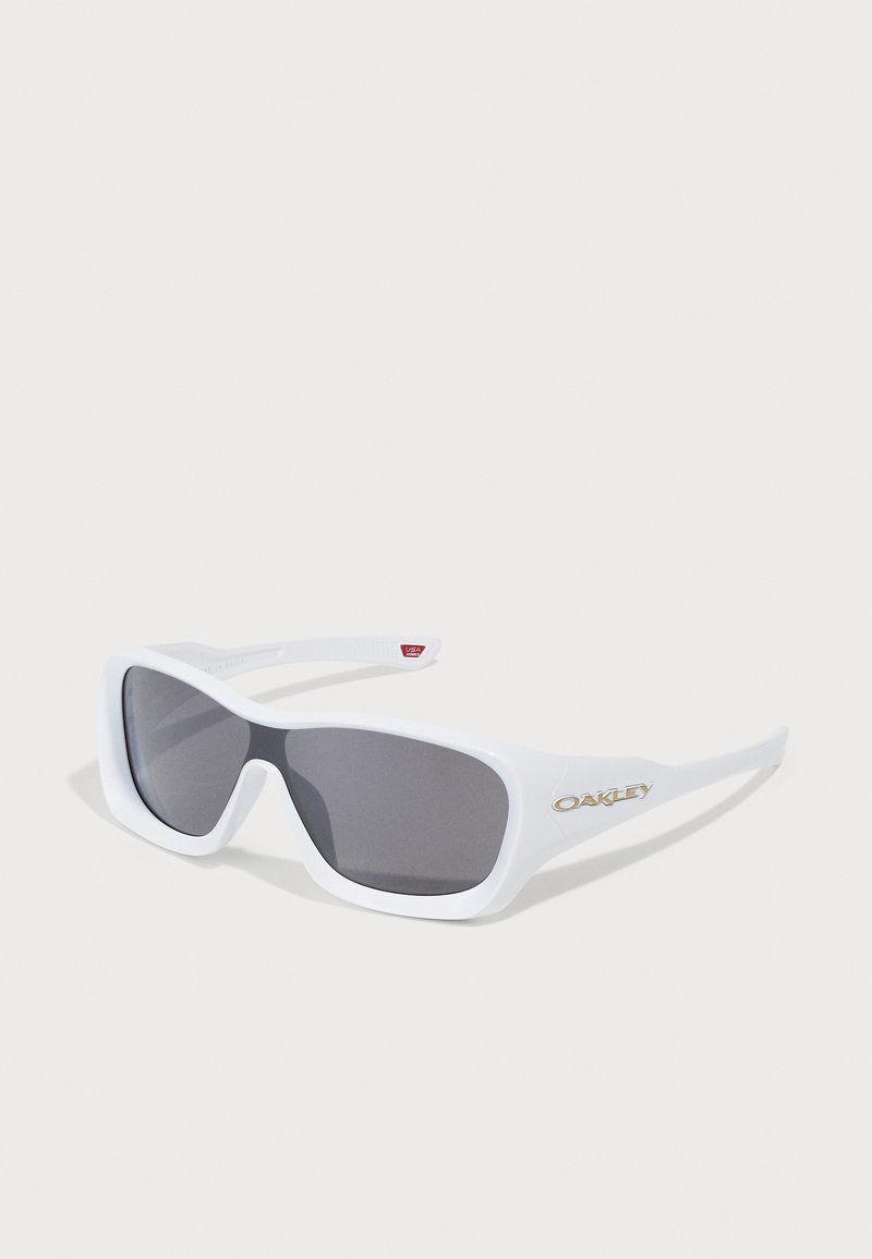 Óculos de sol Oakley retangulares brancos com lentes escuras, repousando sobre uma superfície branca, mostrando o logótipo da marca na haste.