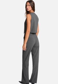 Haut court à rayures grises avec un design structuré, assorti à un pantalon taille haute à rayures grises, tous deux en tissu texturé.