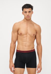 Boxeri negri cu un brâu elastic bordo. Brâul este personalizat cu marca "BJÖRN BORG". Materialul pare neted și ajustat.
