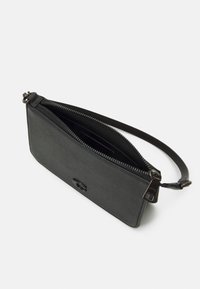 Sort læder håndledspung med en struktureret overflade, der har en lynlås lukning. Indvendigt har den kortlommer og en glat foring.