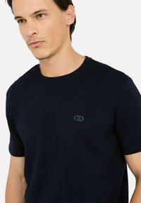 Maglietta a maniche corte blu navy realizzata in tessuto morbido, con collo tondo e un logo ricamato discreto sul petto.