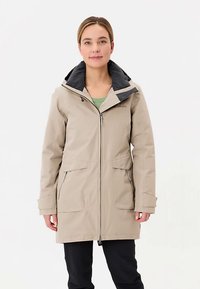 Beige Jacke mit schwarzer Kapuze, ausgestattet mit einem Frontreißverschluss, zwei großen Vorderentaschen und einem leicht taillierten Schnitt. Glatter, strapazierfähiger Stoff.