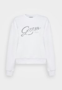 Felpa bianca a maniche lunghe, colletto rotondo e logo ricamato in argento "Guess 1981". Tessuto morbido, design cropped, polsini e orlo a coste.