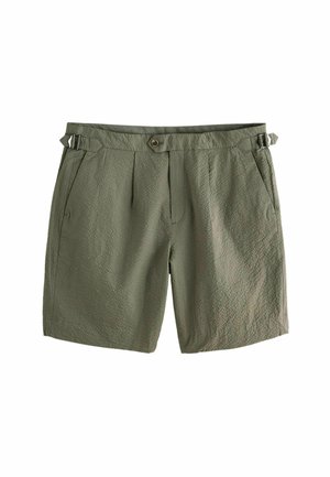 Shorts texturés vert olive avec poches latérales, fermeture par bouton et zip, et sangles latérales ajustables avec boucles métalliques.