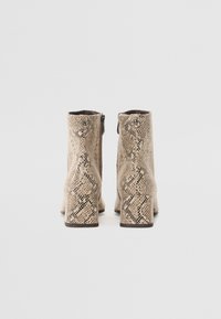 Beige snakeskin-patterned ankle boots with a textured finish, featuring a side zipper and a chunky heel for stability.