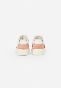 Sneakers met een bovenwerk van wit leer, zachte roze suède accenten en een beige rubberen zool. Voorzien van gezwollen kraag en geperste branding op de hiel.