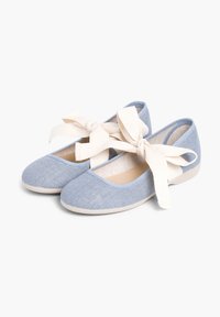 Blaue Stoff-Ballerinas mit strukturierter Oberfläche, runder Zehenpartie und beigen Stoffschleifen, die am Knöchel gebunden sind. Weiche Sohle.