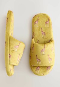 Yellow slippers with a soft, plush texture featuring a giraffe pattern. Open-toe design and cushioned straps for comfort.