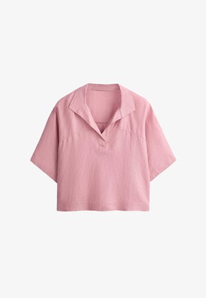 Chemise ample en lin rose à manches courtes, avec un col large ouvert et un décolleté en forme de V.