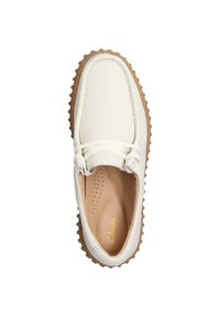 Scarpa in pelle bianca con punta arrotondata, suola in gomma beige e lacci tonali. L'interno presenta perforazioni e un marchio dorato.