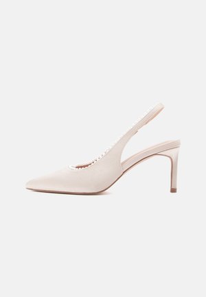 Chaussure à talon haut à bride arrière en satin beige, avec un bout pointu, un décolleté découpé et des accents décoratifs en perles le long du bord.